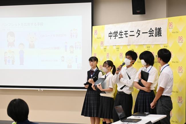 写真：スクリーンの隣で発表する中学生たち